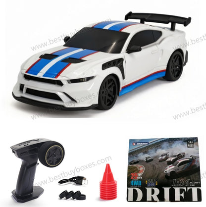 White remote control drift car with blue and red racing stripes, shown with a black handheld remote control, USB charging cable, black tire covers, a red cone, and the product packaging box.